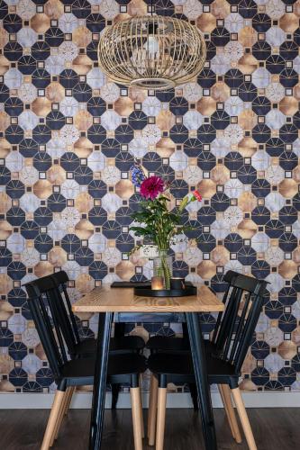 a dining room table with two chairs and a vase of flowers at @ geulle in Guelle
