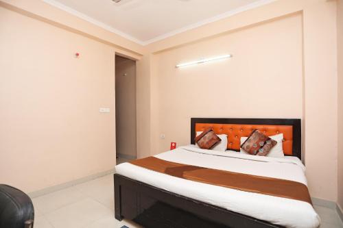 een slaapkamer met een groot bed met een oranje hoofdeinde bij OYO Rn 32 in Indirapuram