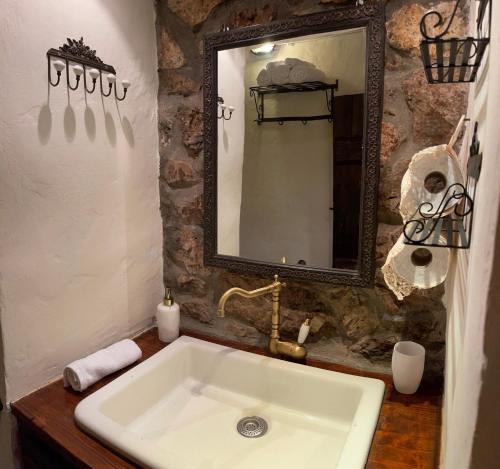 uma casa de banho com um lavatório e um espelho em Agoriani Art Studio - Sweet little cottage em Lílaia