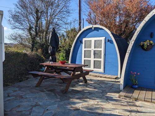 a picnic table in front of a blue shed at A house and a half on Beara peninsula in Castletownbere