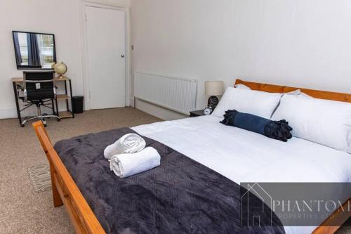 ein Schlafzimmer mit einem großen Bett mit Handtüchern darauf in der Unterkunft Complex Suite in Glasgow