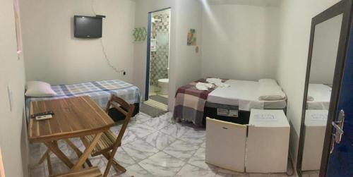 a room with a bed and a table in a room at Pousada Maceio Praia in Maceió