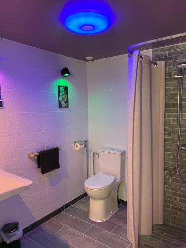 a bathroom with a toilet and a blue light at Love room - love Abella box, location adulte in Saint-Étienne-au-Mont