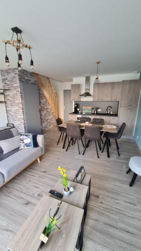 un salon avec un canapé et une table dans l'établissement L'Oléron, à Saint-Rémy-Boscrocourt