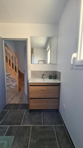 une salle de bain avec un lavabo et un miroir dans l'établissement L'Oléron, à Saint-Rémy-Boscrocourt
