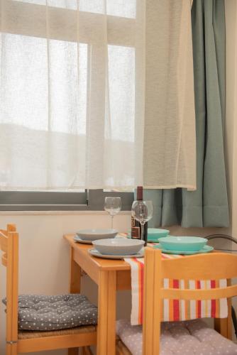 a table with two chairs and a table with glasses at Tsaner Apartment and Rooms in Matala