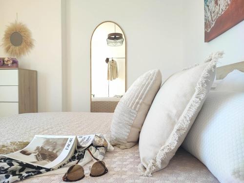 a bedroom with a bed with pillows and a mirror at Mirador do Mar, encima de la playa in Moaña