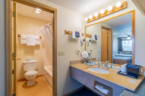 a bathroom with a sink and a toilet and a mirror at Resort City Inn Coeur d Alene in Coeur d'Alene