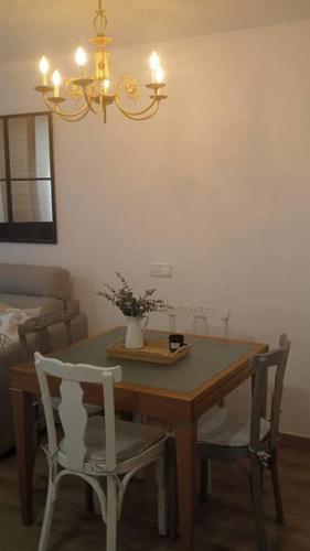 a dining room table with two chairs and a vase on it at Apartamento Bayyana in Baena