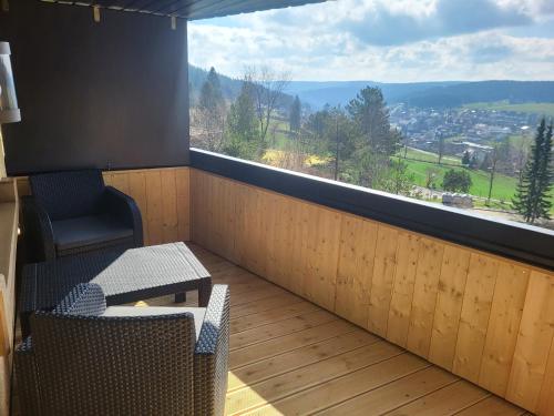 a balcony with a table and a chair and a window at Apartment Fabelwald Black Forest in Schonach
