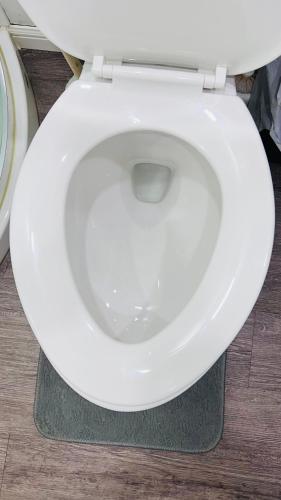 a white toilet seat with the lid down in a bathroom at The Home Sweet Home in Winnipeg