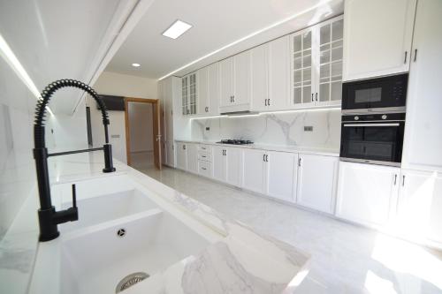 eine große Küche mit weißen Schränken und einem Waschbecken in der Unterkunft Villa Écologique à Proximité de la Plage in Agadir