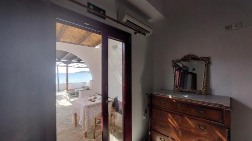 een spiegel en een ladekast in een kamer met uitzicht op de oceaan bij Styfilia Beachfront Apartment - Ground Floor in Sifnos