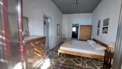 een slaapkamer met een bed en een badkamer met een douche bij Styfilia Beachfront Apartment - Ground Floor in Sifnos