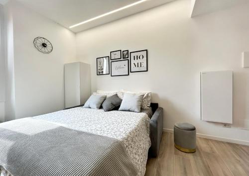 - une chambre blanche avec un lit et une horloge murale dans l'établissement Casa Vacanza Milano, à Milan
