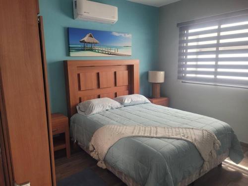 a bedroom with a bed with a blue wall at Bring the family to Mazatlán in Mazatlán