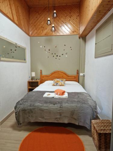 a bedroom with a large bed with a wooden headboard at Pensión O Muiño in O Pedrouzo