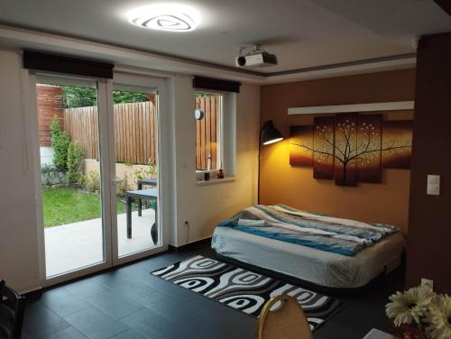 a bedroom with a bed and a sliding glass door at Italia House in Fót