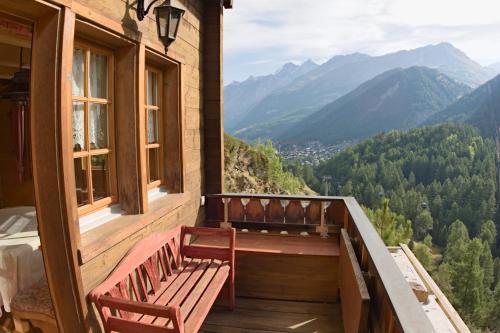 a porch with a bench and a view of mountains at Zermattmountainchalet Tambiel in Zermatt