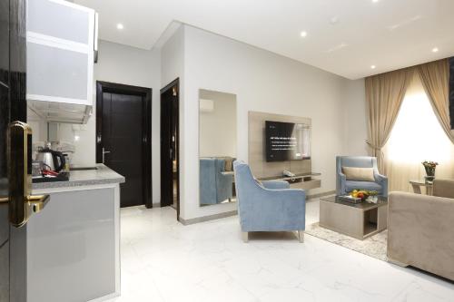 uma cozinha com uma cadeira azul e uma sala de estar em وايت مون للأجنحة الفندقية -الرصراص em Khamis Mushayt