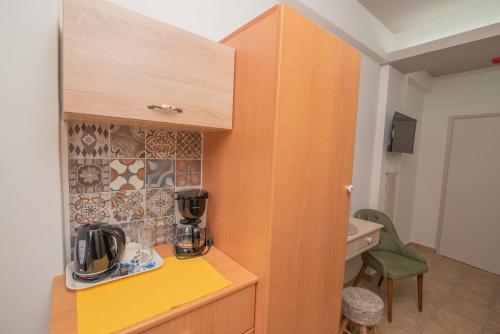 a small kitchen with a yellow counter and a sink at Tsaner Apartment and Rooms in Matala