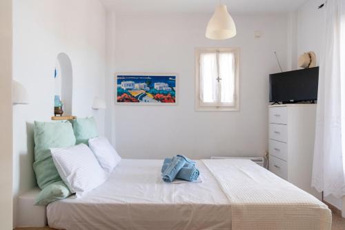 a white bedroom with a bed and a television at Cycladic home in Paros in Kampos Paros