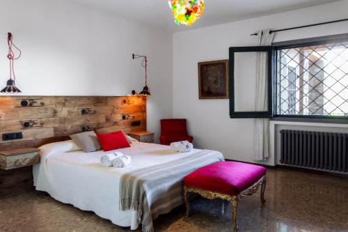 Schlafzimmer mit einem weißen Bett und einem roten Stuhl in der Unterkunft Finca Bell-Lloc in Palamós