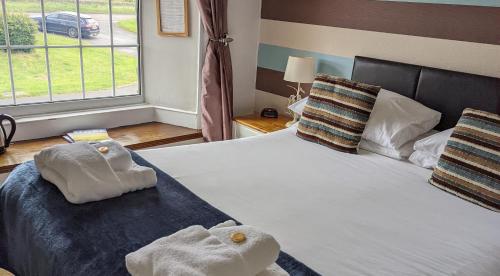 ein Schlafzimmer mit einem Bett mit Handtüchern darauf in der Unterkunft The Manor House Inn in Shotley Bridge
