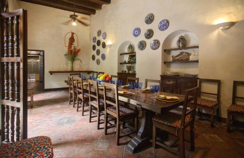 uma sala de jantar com uma mesa e cadeiras e pratos na parede em 4CB-1 CASA COLONIAL DE 4 HABITACIONES EN EL CENTRO HISTORICO DE CARTAGENA em Cartagena das Índias