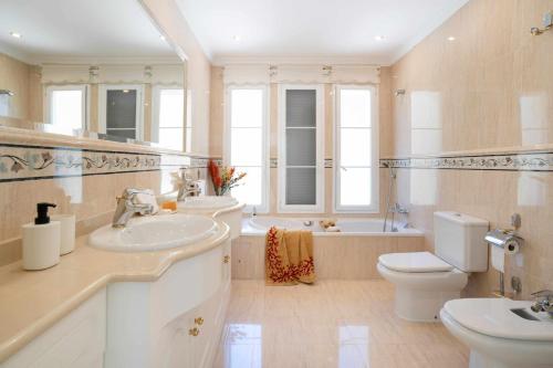 bagno con 2 lavandini, servizi igienici e vasca di villa de lujo en javea a Jávea