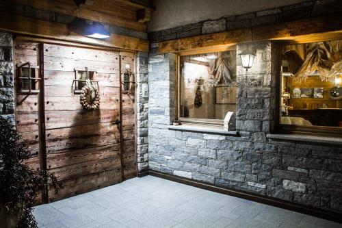 Ellex Eco Hotel في غريسّوني لا ترينيتي: غرفة بجدار حجري وباب خشبي