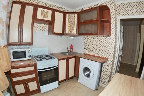 a small kitchen with a washer and dryer in it at Венеция in Petropavlovsk