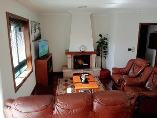 uma sala de estar com duas cadeiras de couro e uma mesa em Apartamento Alvares Cabral em Vila Nova de Gaia