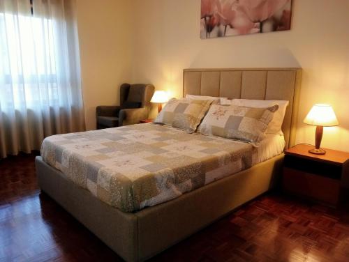 1 dormitorio con 1 cama con silla y ventana en Apartamento Alvares Cabral en Vila Nova de Gaia