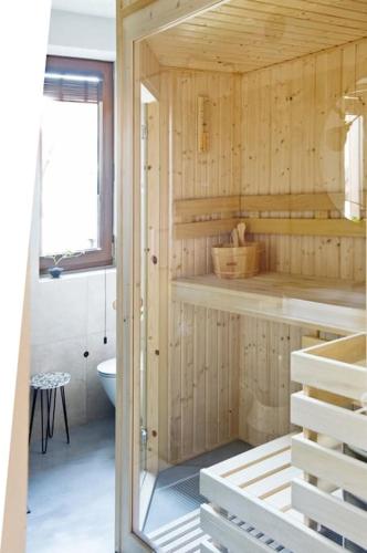 a wooden bathroom with a toilet and a window at Apartament Czerwona Łasica in Jaworki