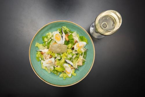 a green plate of salad with eggs on a table at Holiday Inn Preston by IHG in Preston