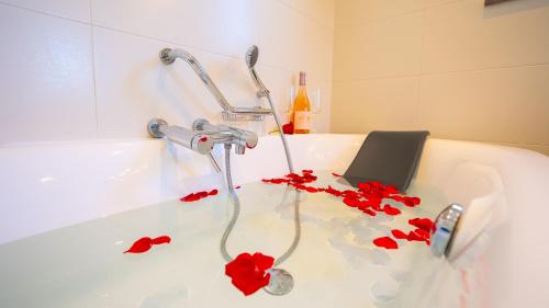 een bad gevuld met rode rozenblaadjes bij Ocean View Villa in Boliqueime