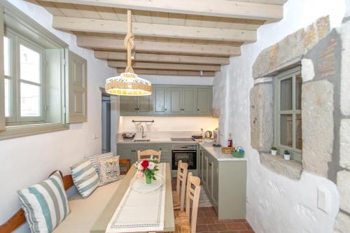 uma cozinha com uma mesa e cadeiras e um tecto em Patmos Traditional House Chora near the Monastery em Patmos