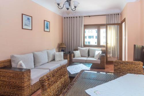 ein Wohnzimmer mit einem Sofa und einem Tisch in der Unterkunft Appartement Marina Beach - Belle Vue in Mʼdik