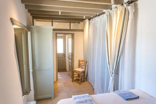 um quarto com uma cama, uma janela e uma cadeira em Patmos Traditional House Chora near the Monastery em Patmos