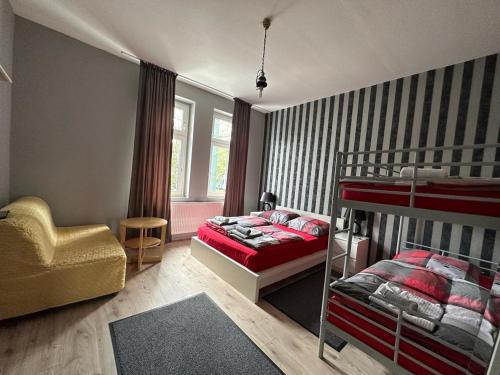 a bedroom with two bunk beds and a chair at Adam's Hostel - Self Check-In & Room Just For You Alone in Düsseldorf