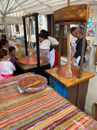 a group of people in a kitchen preparing food at Casa vacanze “Dolce sosta” in Quartu SantʼElena