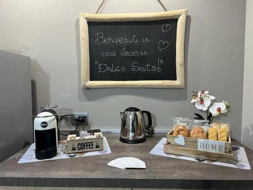 a table with pastries and a chalk board with a sign at Casa vacanze “Dolce sosta” in Quartu SantʼElena