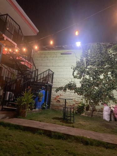 a man standing outside of a house at night at Hostal El Jardin in León