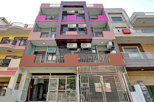 a pink building with chairs on the balcony at Super OYO The Prima Residency in Ghaziabad