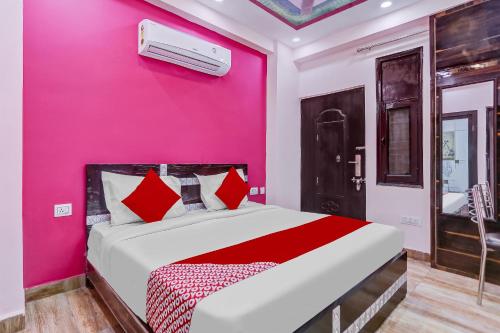 a bedroom with a pink wall and a bed at Super OYO The Prima Residency in Ghaziabad