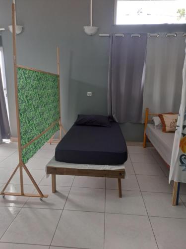 een kamer met een bed en een bedframe bij Laure hébergement loue lits en dortoir in Faaa