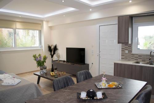 a living room with a dining table and a kitchen at Amare suite in Perivólia