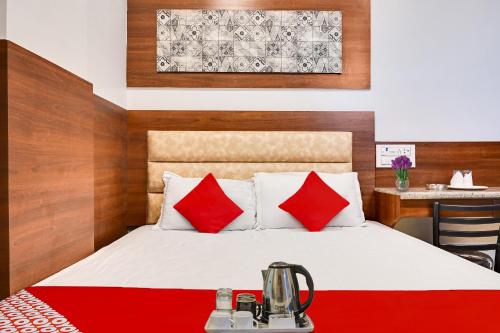 a hotel room with a bed with red pillows at Classic Court in Patna
