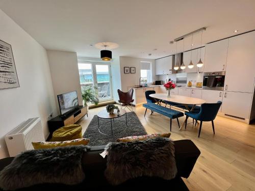 a living room with a couch and a table at Walnut Tree Penthouse Next to Train Station in Cambridge